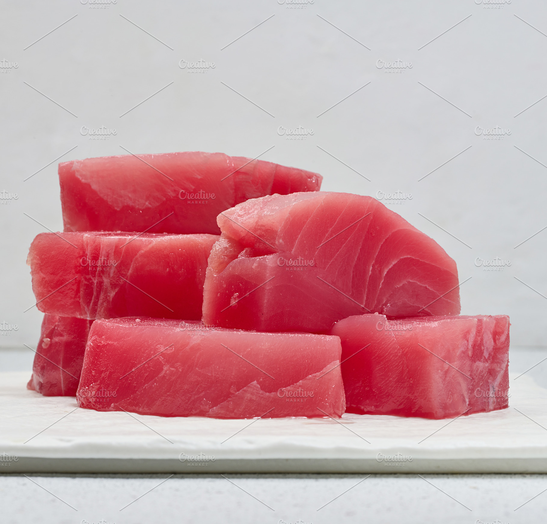 A stack of raw tuna pieces on a white board, a Food & Drink Photo by ndanko