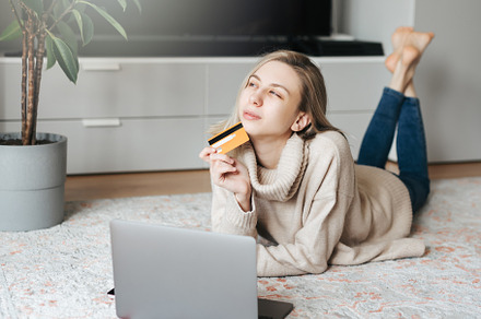 Young woman holding credit card and using laptop computer., a Person Photo by Olena Rudo