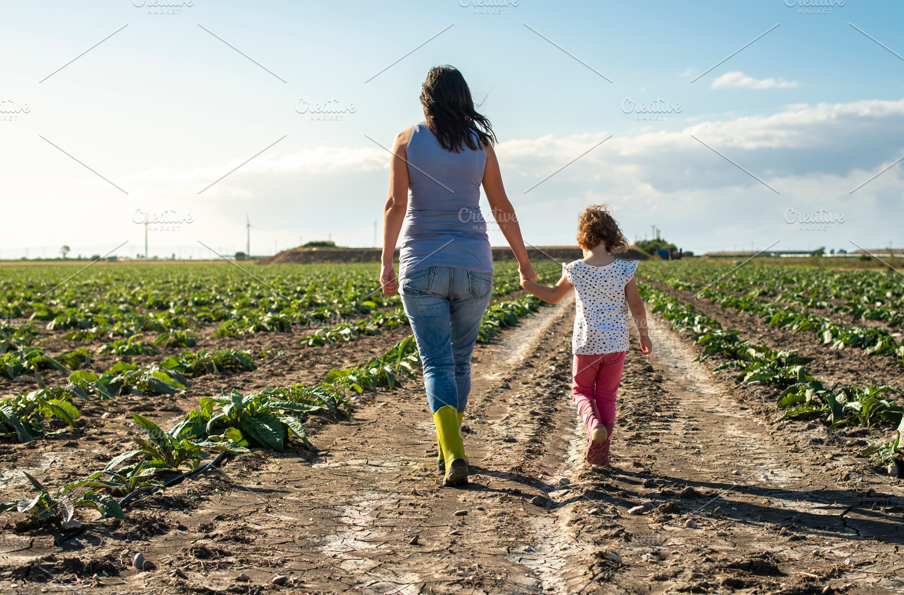 Woman farmer and little girl walking containing woman, child, and garden, a Person Photo by Deyan Georgiev
