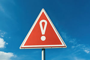 A triangular warning sign with an exclamation mark stands prominently against a, an Abstract Photo by AlyaAnd