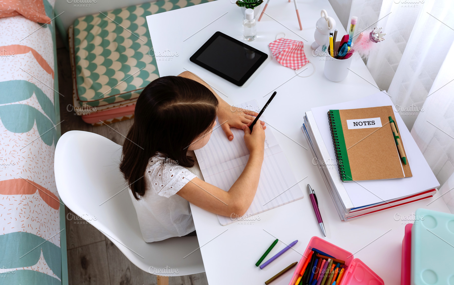 Girl studying at home with tablet and mask on table, a School & Education Photo by davidpereiras