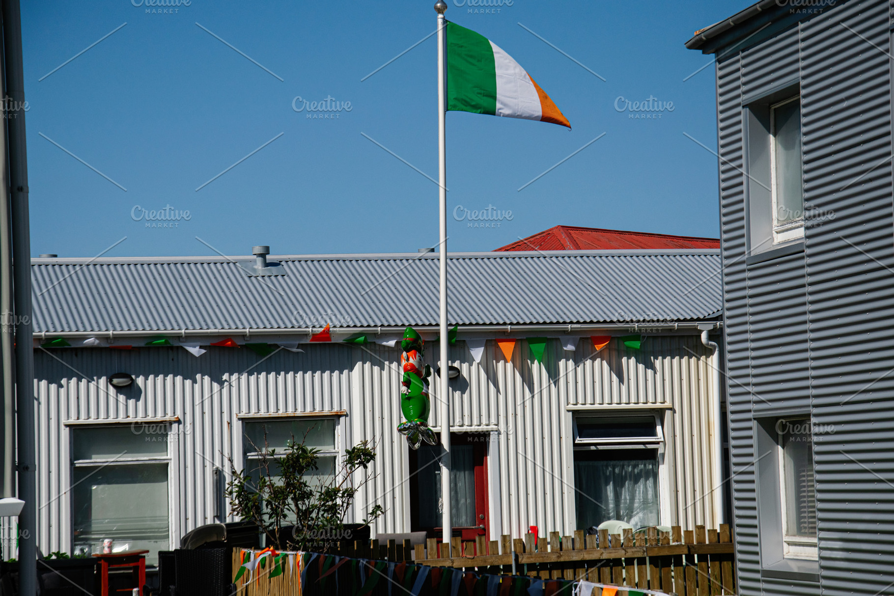 Ireland flag with Irish decorations in Akranes, Iceland under blue skies, a Photo by AS photostudio
