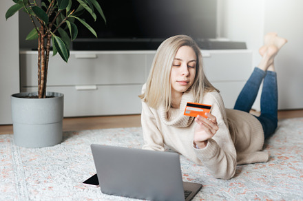 Young woman holding credit card and using laptop computer., a Business Photo by Olena Rudo