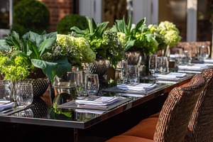 Elegant outdoor dining table set with fresh green floral centerp, a Photo by Studio ANNA