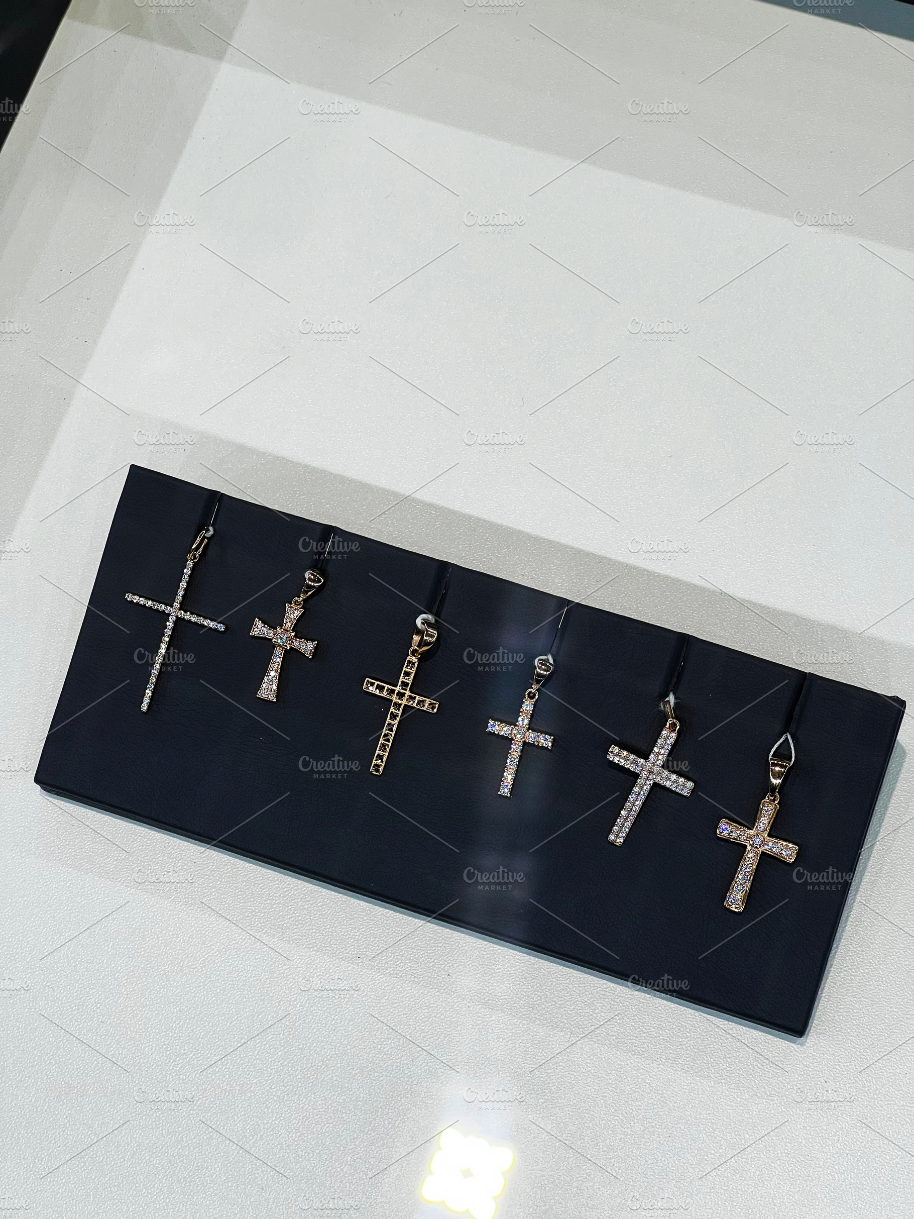 Collection of decorative cross pendants displayed on a dark background, a Photo by AS photostudio