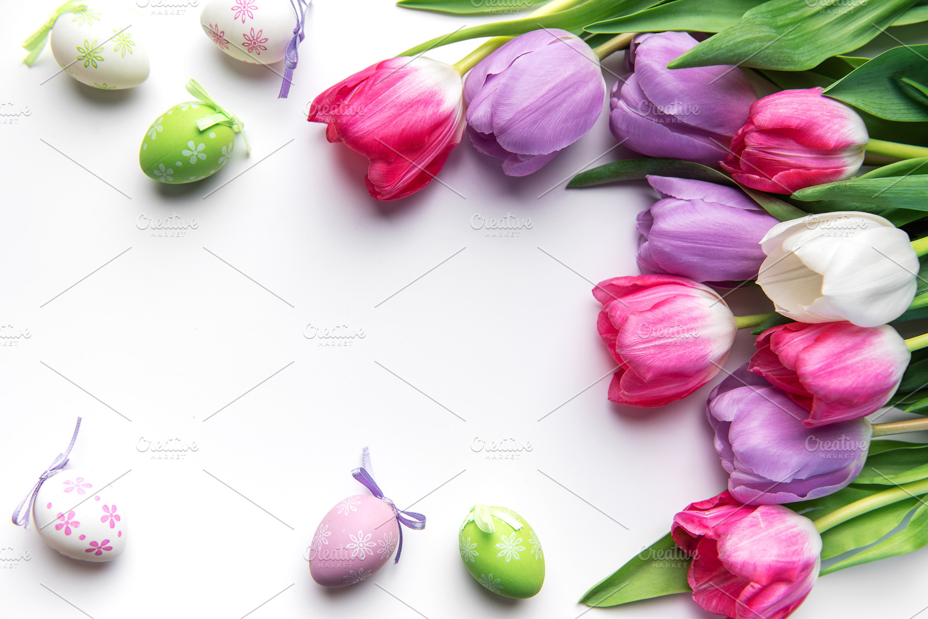 Colorful easter eggs and tulips creating spring border, a Holiday Photo by Olena Rudo