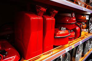 Red metal fuel containers on display in a hardware store shelf section, a Photo by AS photostudio