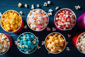 Paper cups with colorful popcorn on wooden background, a Food & Drink Photo by AlyaAnd