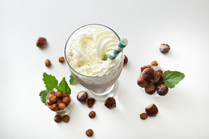 Glass with hazelnut smoothie with cream and bowls top view, a Food & Drink Photo by Davizro's Market