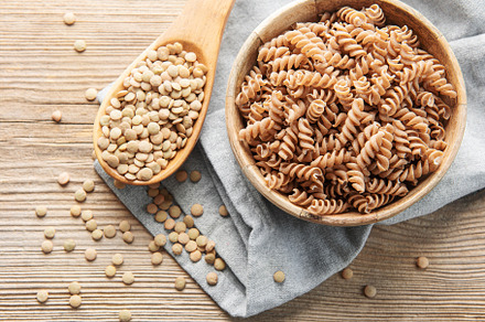 Green lentil fusilli pasta on a old wooden background., a Food & Drink Photo by Olena Rudo
