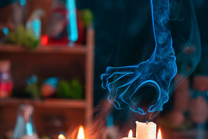 Mystical smoke hand extinguishing a