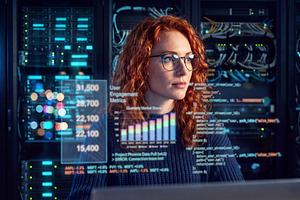 Redhair female IT specialist in glasses operating network server, a Technology Photo by Volff