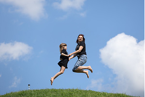 Mother and daughter happily jumping, a Nature Photo by Nenahliadava Design
