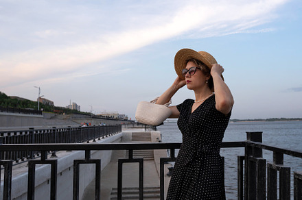 Woman adjusts straw hat