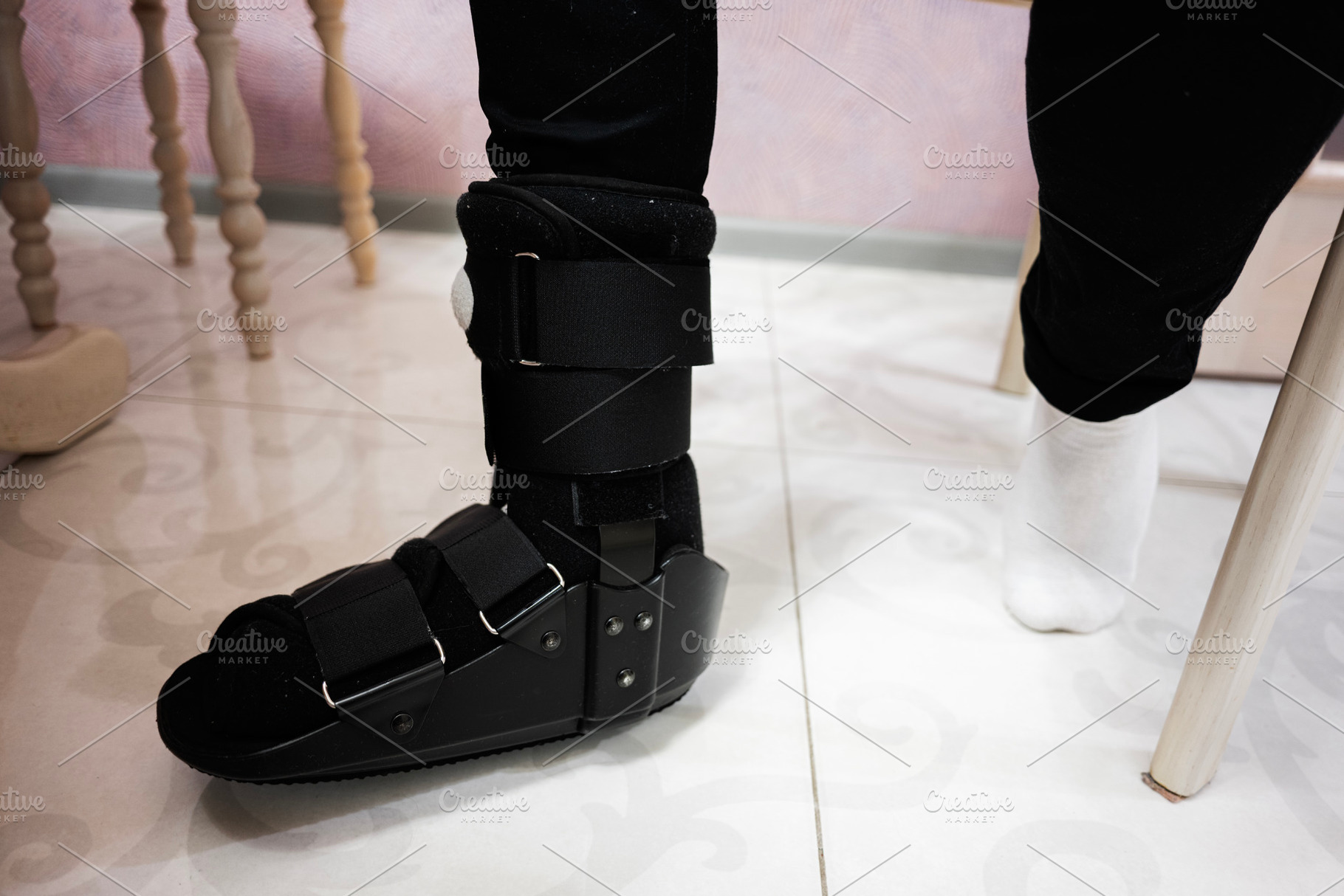 Close-up of an orthopedic foot brace on a tiled indoor surface, a Health & Medical Photo by AS photostudio