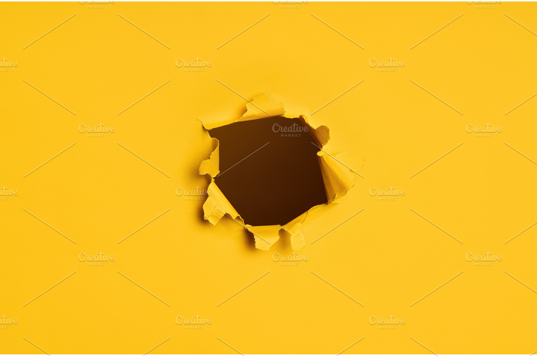 Torn hole in yellow paper with dark, a Background Photo by Gladkov photography
