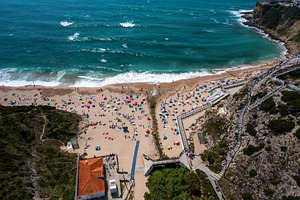 Aerial drone view of anonymous tourists at scenic Magoito Beach, a Photo by andreonegin market