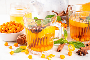 Sea buckthorn hot tea  drink with orange zest, cinnamon spices a, a Food & Drink Photo by Rimma