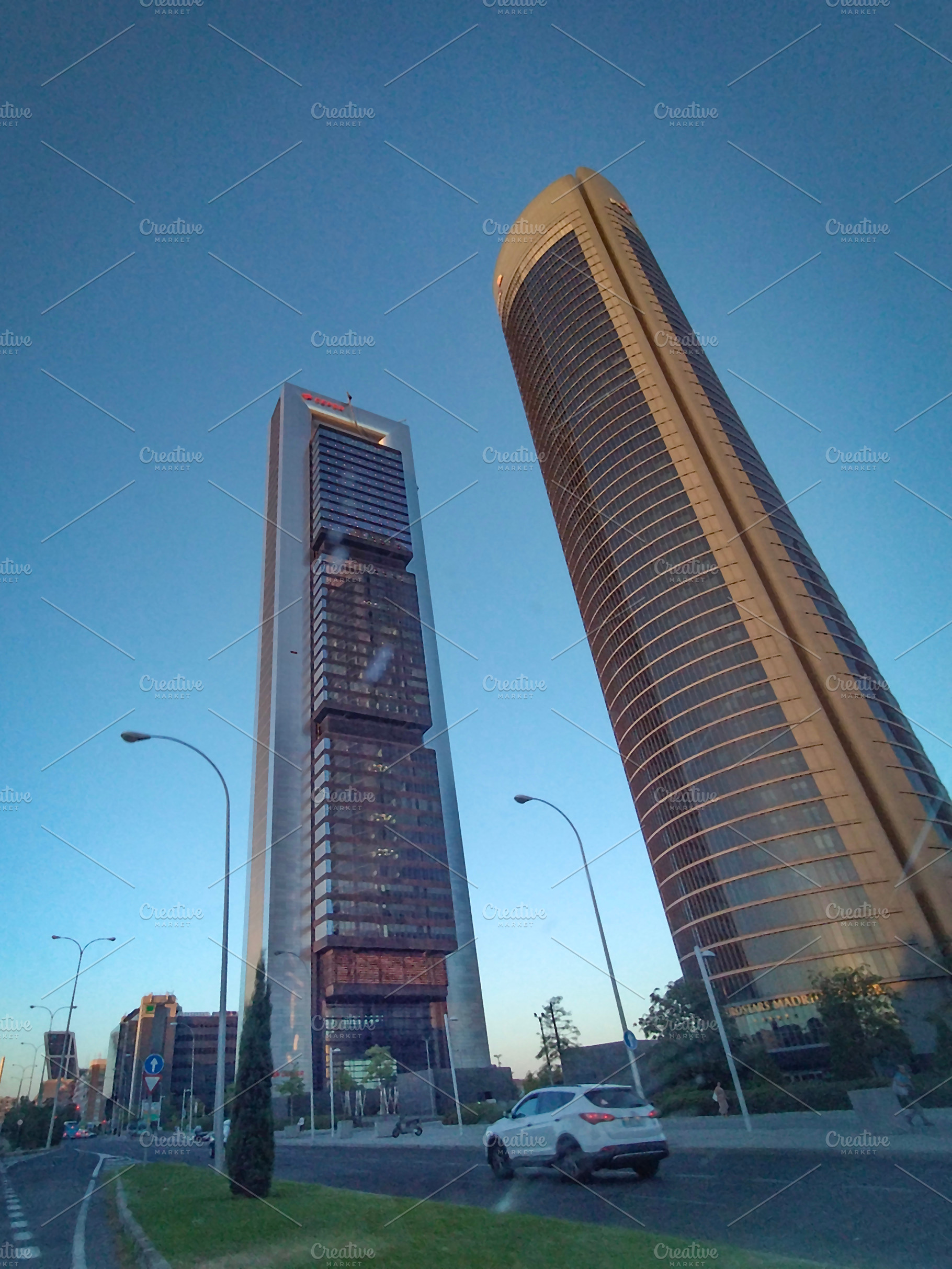 Tall skyscrapers with reflective glass under blue sky, an Architecture Photo by DanFLCreativo