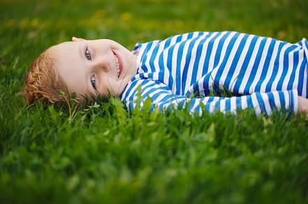 Little boy lying on the grass containing green, grass, and boy