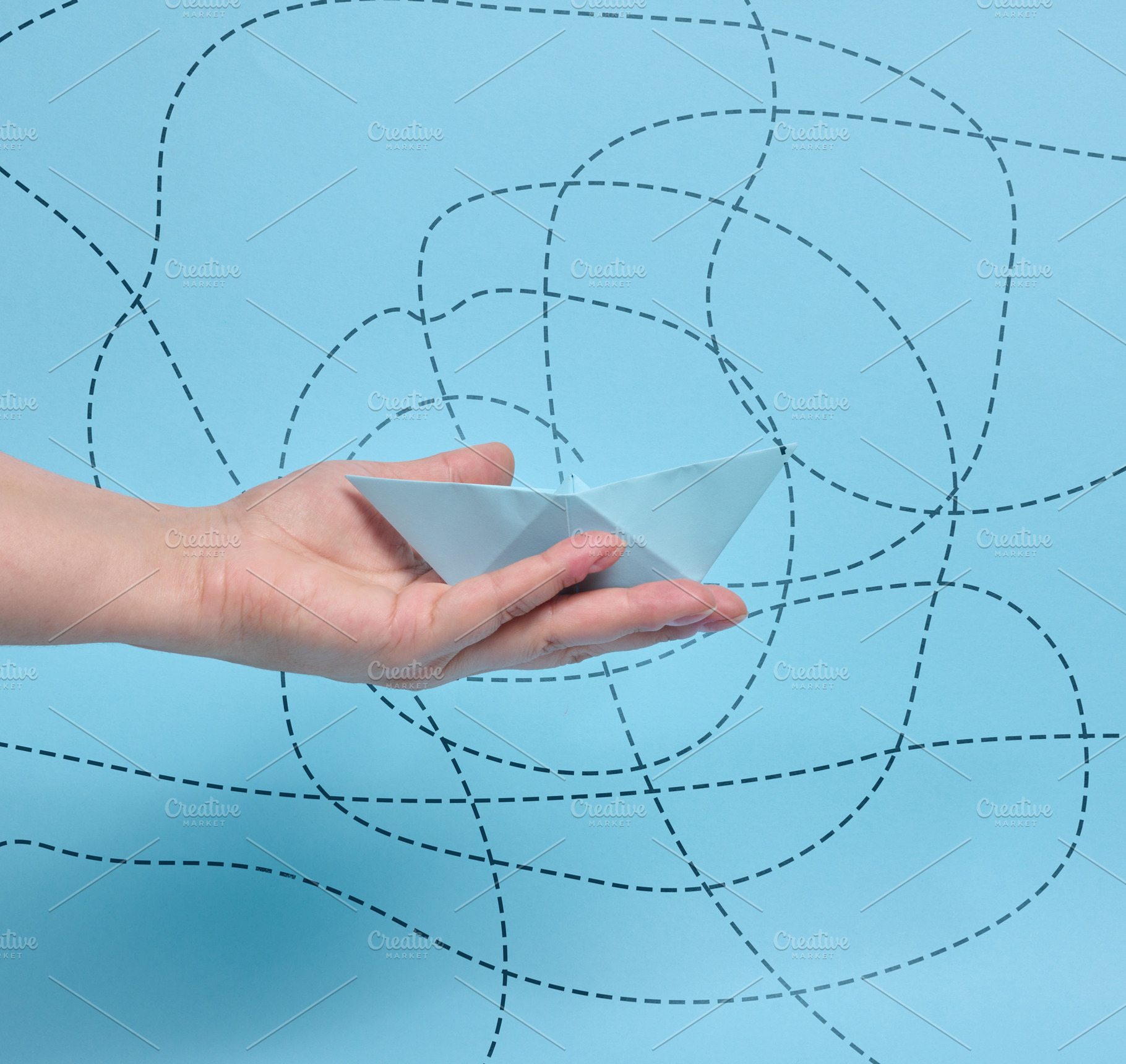 A person holding a paper boat on their palm against a background, a Business Photo by ndanko