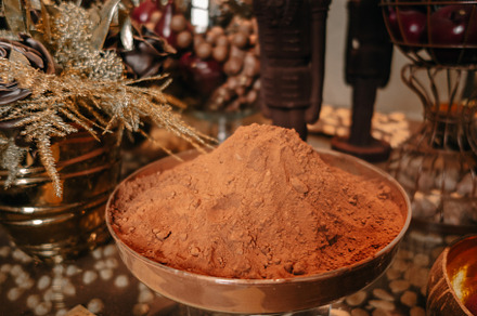 Cocoa powder in a metal cup on a rustic table, a Food & Drink Photo by GoodGoods