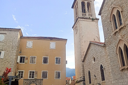 Narrow stone street with a big tower, an Architecture Photo by Photo by YuraYaryna