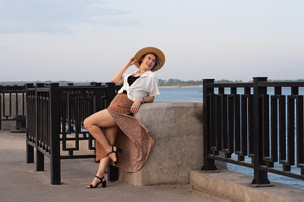 Smiling woman reclines on river wall
