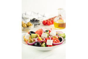 Greek salad on the table, vertical, a Food & Drink Photo by Fascinadora
