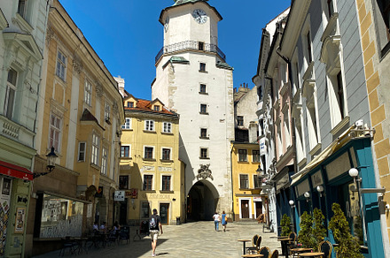 Historic street in Bratislava with St. Michael's Gate under a cl