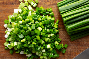 Organic Cut Green Onion Scallions on a Wooden Board, top view., a Food & Drink Photo by LiudmylaChuhunova