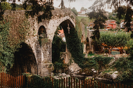 Ivy-covered Roman bridge at dusk in