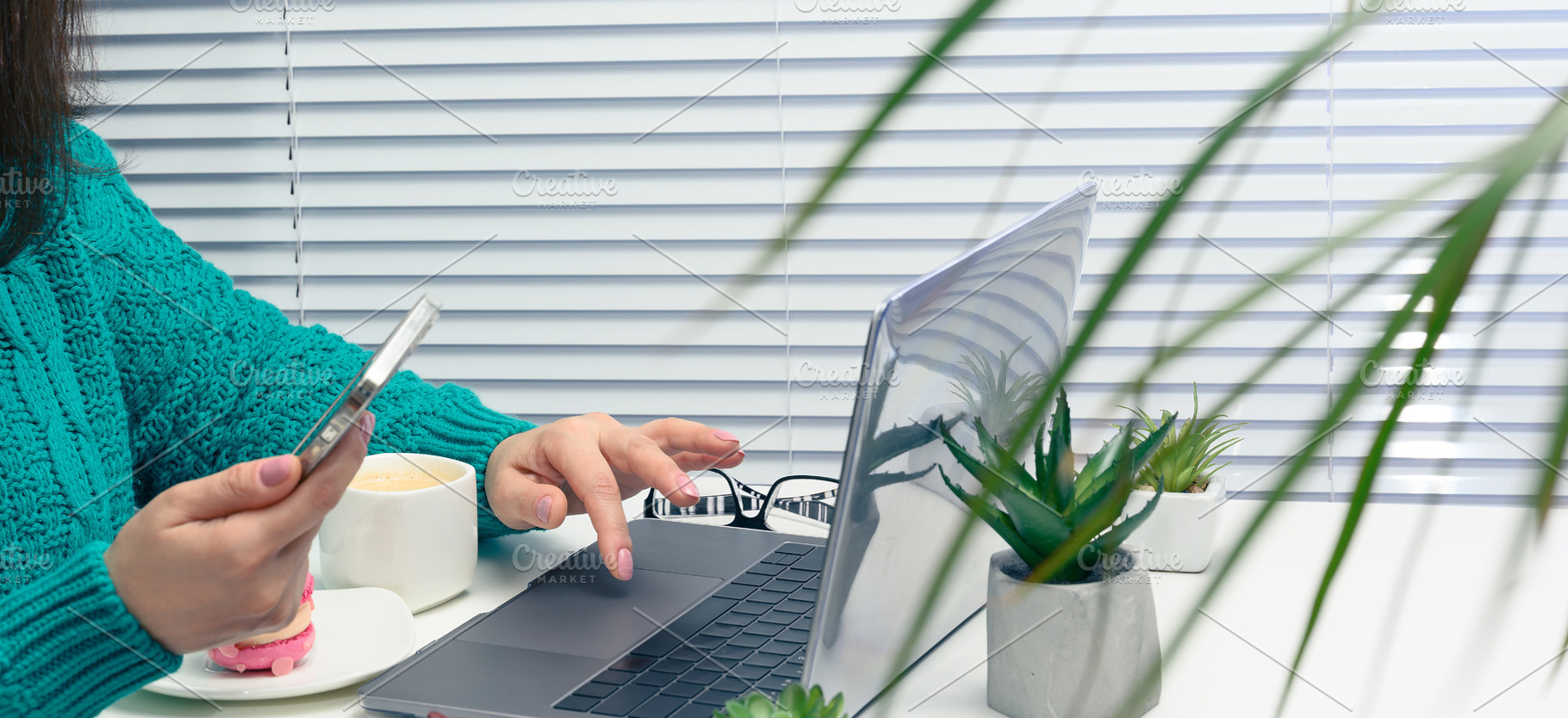 A woman working on a laptop and using a smartphone, an office de, a Person Photo by ndanko