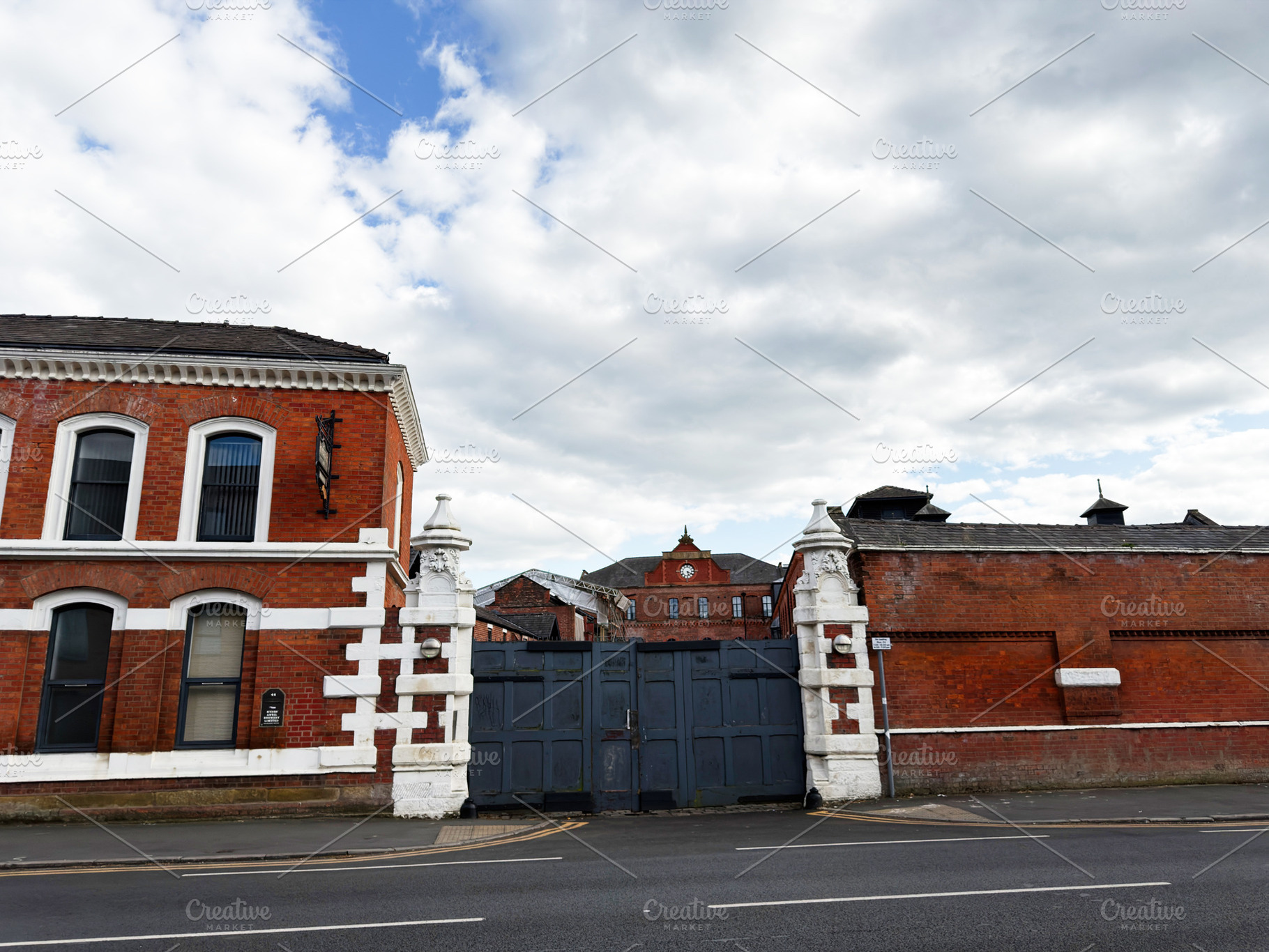 Historic red brick industrial gate and courtyard in Manchester,, a Photo by AS photostudio