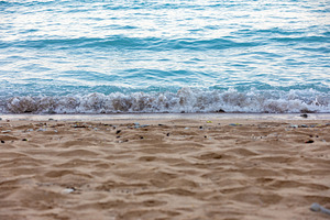 Close-up of gentle waves rolling onto a sandy beach with clear blue water, perf, a Nature Photo by Ales Munt