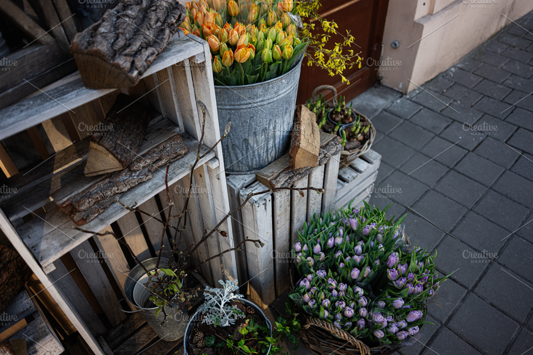 Beautiful tulips and decorations arranged on sidewalk display, a Photo by AS photostudio