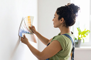 Home decorator showing wall paint samples to homeowners inside a, a Person Photo by DanFLCreativo