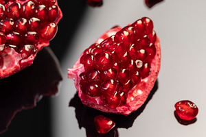 large ripe pomegranate seeds on the table, a Photo by rsoollAI