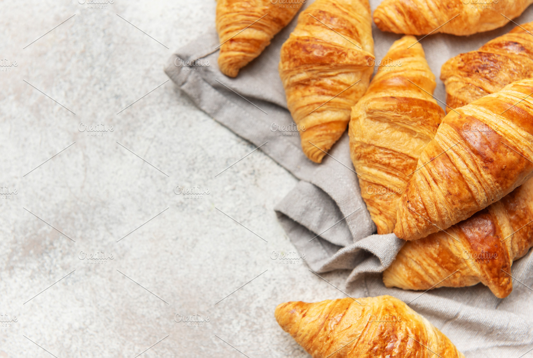Freshly baked croissants resting on a gray cloth napkin, a Food & Drink Photo by Olena Rudo
