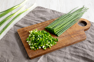 Organic Cut Green Onion Scallions on a Wooden Board, side view., a Food & Drink Photo by LiudmylaChuhunova
