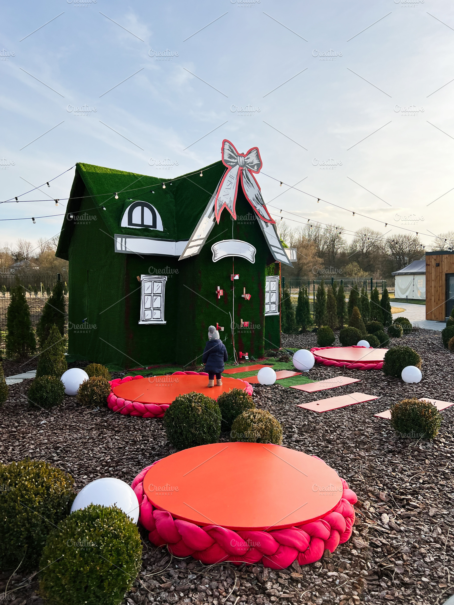 Festive outdoor display featuring a decorated green house with vibrant holiday, a Photo by AS photostudio