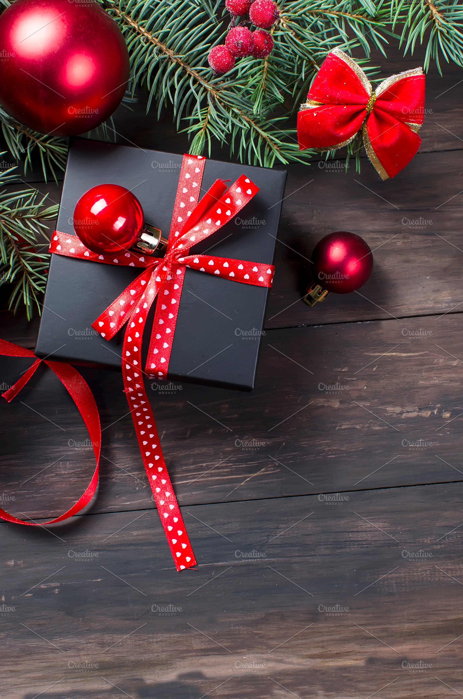 Black christmas gift box with red ribbon and fir branches, a Holiday Photo by vimart