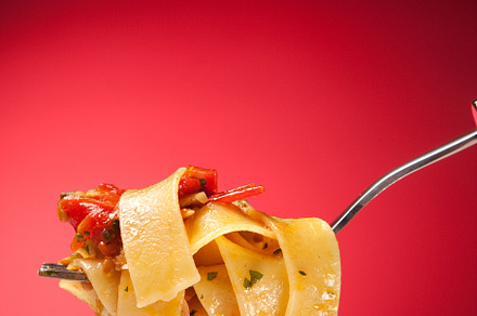 Tagliatelle with clams on a red background