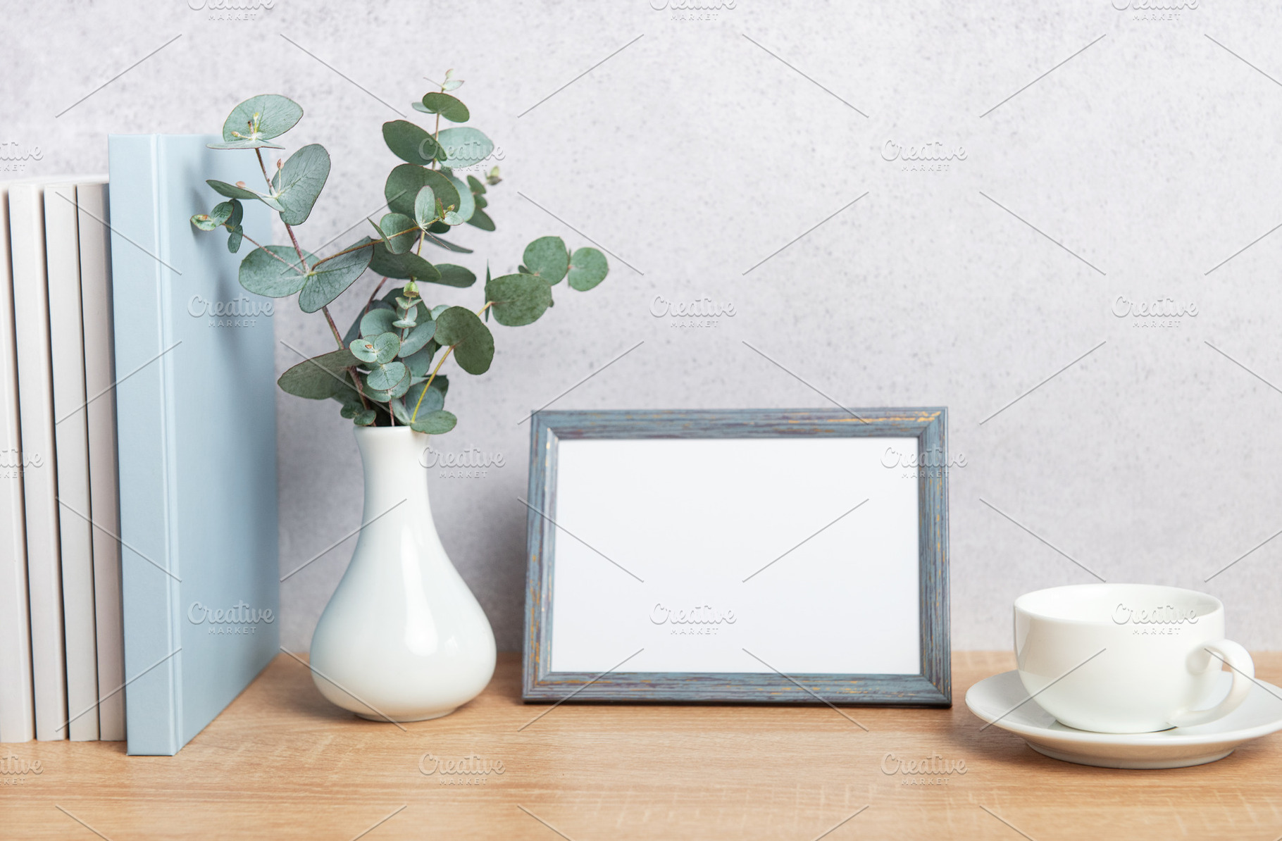 Eucalyptus branches, books, empty frame and coffee cup creating, a Background Photo by Olena Rudo
