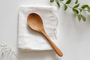 Wooden spoon on white napkin, a Food & Drink Photo by Virgo Studio