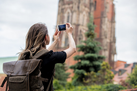 young girl with a smartphone on the background of the old church, a Person Photo by Masson Simon