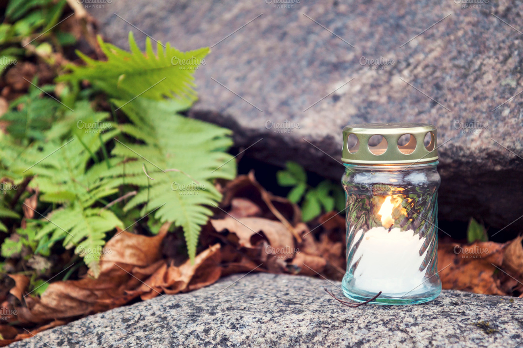 Candle standing on tombstone, a Nature Photo by BOOCYS