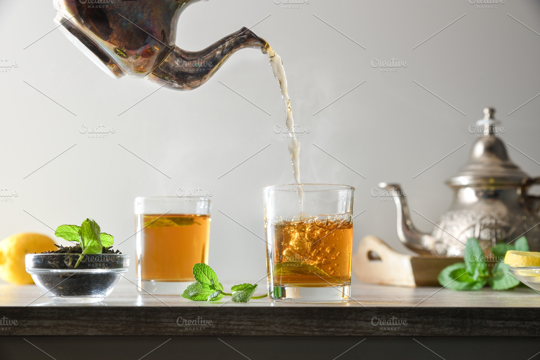 Pouring green tea from a metal teapot isolated background, a Food & Drink Photo by Davizro's Market