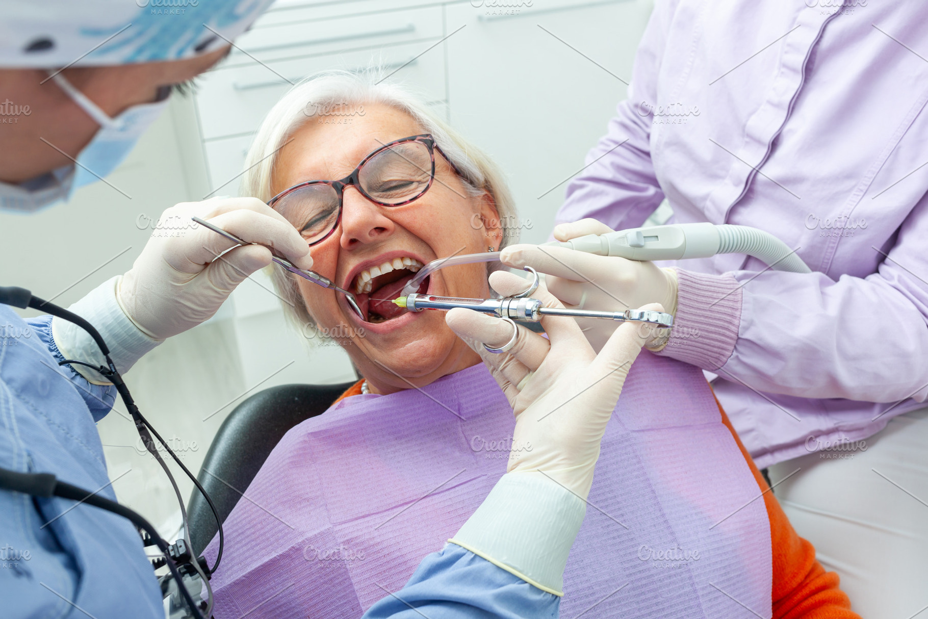 Dentist giving anesthesia to senior patient in clinic, a Health & Medical Photo by Antonio Gravante Market
