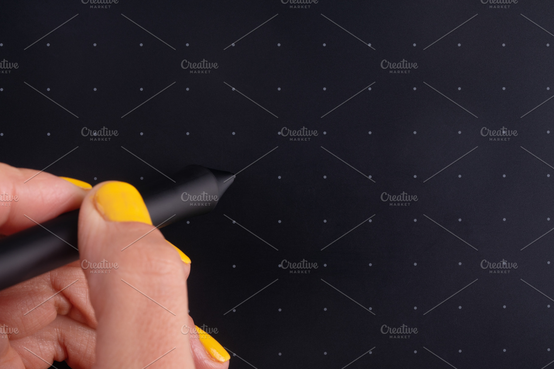 Close-up of a hand holding a stylus on a black graphics tablet w, a Business Photo by Ales Munt